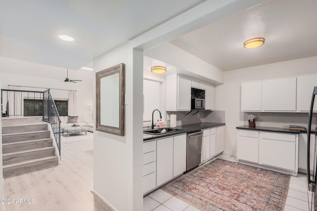 kitchen featuring dishwasher, light hardwood / wood-style floors, sink, white cabinetry, and ceiling fan