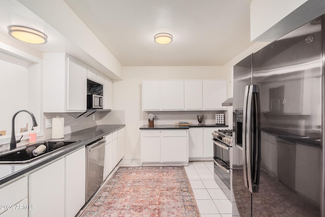 kitchen featuring decorative backsplash, white cabinetry, appliances with stainless steel finishes, and sink