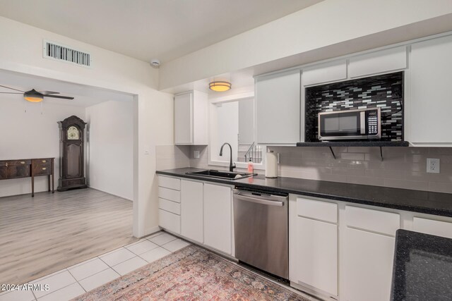 kitchen featuring ceiling fan, sink, stainless steel dishwasher, white cabinetry, and light hardwood / wood-style floors