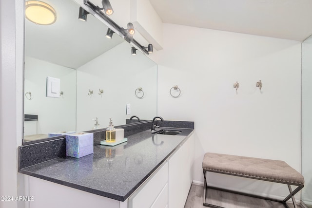 bathroom featuring lofted ceiling, vanity, and hardwood / wood-style flooring