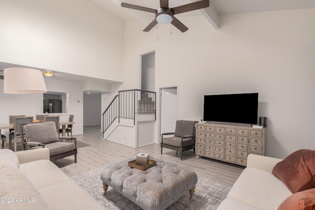 living room featuring light hardwood / wood-style floors, ceiling fan, beamed ceiling, and high vaulted ceiling