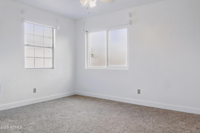 carpeted empty room featuring ceiling fan and baseboards