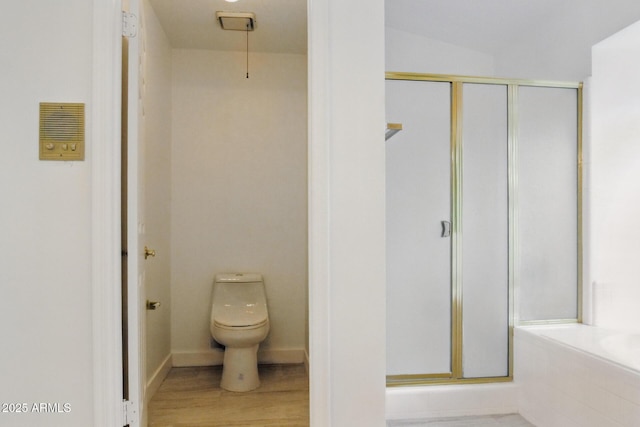 full bathroom with wood finished floors, baseboards, a tub, a shower stall, and toilet