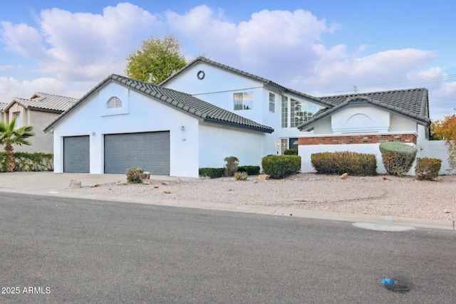 view of front of house with a tile roof, concrete driveway, a garage, and stucco siding