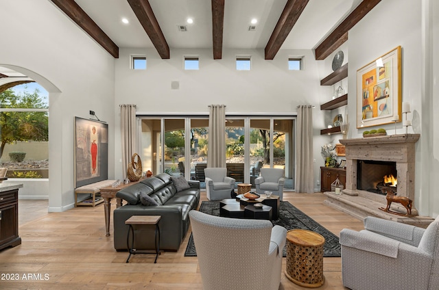 living room featuring light wood-type flooring, a high ceiling, and plenty of natural light