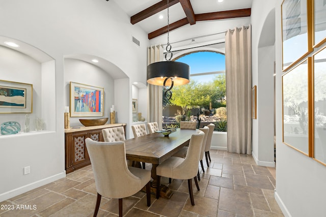 dining space featuring beamed ceiling and high vaulted ceiling