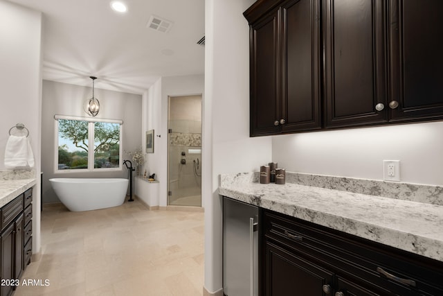 interior space with dark brown cabinetry, light stone countertops, and pendant lighting