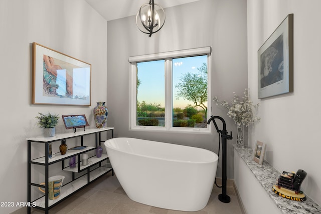 bathroom with a notable chandelier, tile patterned flooring, and a bath