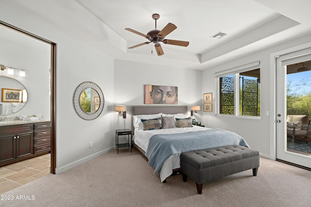 carpeted bedroom with access to outside, a raised ceiling, ensuite bath, and ceiling fan