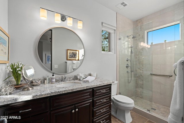 bathroom featuring vanity, a shower with door, a healthy amount of sunlight, and toilet