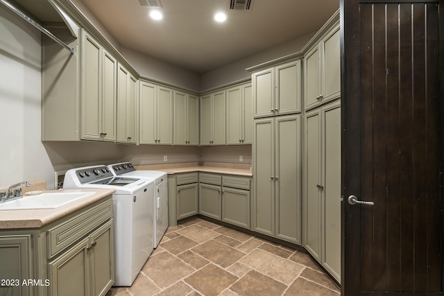 washroom with separate washer and dryer, cabinets, and sink