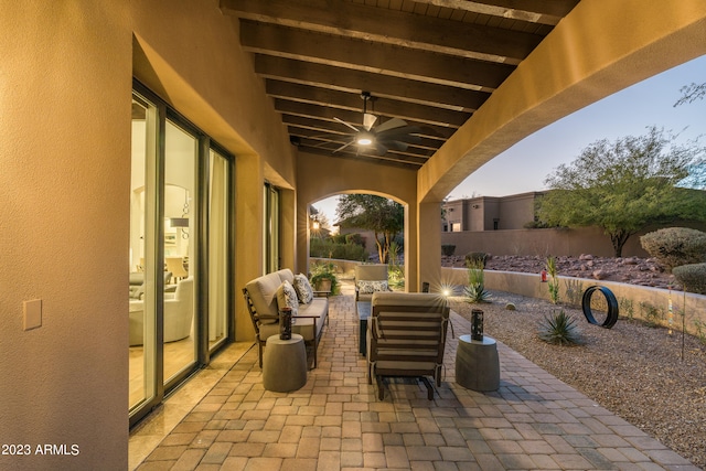 patio terrace at dusk featuring an outdoor living space and ceiling fan