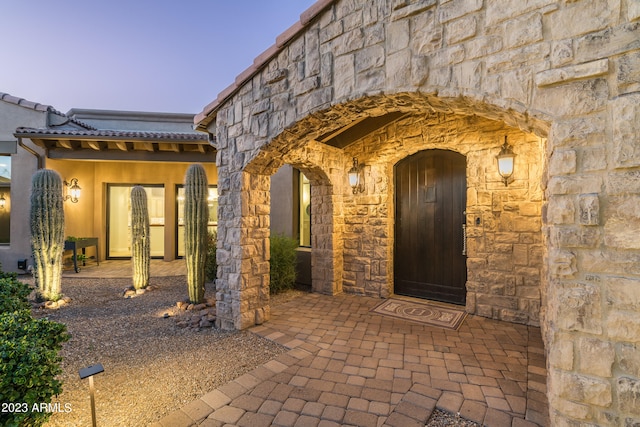 exterior entry at dusk with a patio