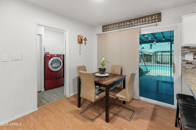 dining area with light wood-type flooring, baseboards, and washer / clothes dryer