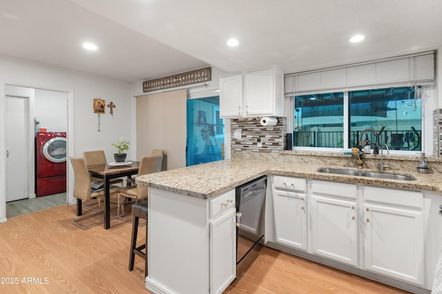 kitchen with light wood-style floors, washer / clothes dryer, dishwasher, and a sink