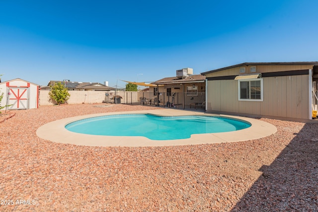 view of pool featuring a storage shed, a fenced in pool, a patio, a fenced backyard, and an outdoor structure