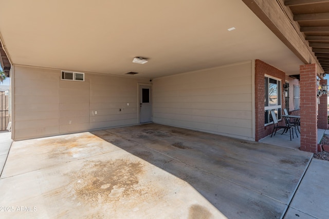 view of patio / terrace with an attached carport, visible vents, and driveway