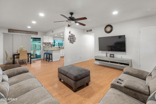 living area with light wood-type flooring, visible vents, and recessed lighting