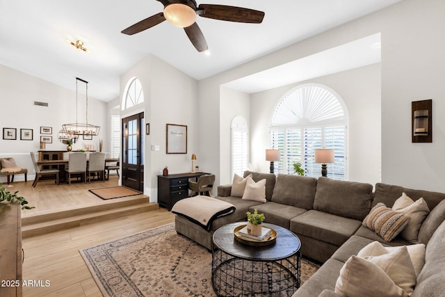 9821 E Windrose Dr, Scottsdale, AZ 85260 - living area with a ceiling fan, lofted ceiling, light wood-type flooring, and a chandelier