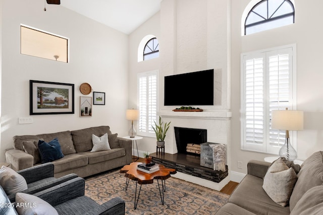 9821 E Windrose Dr, Scottsdale, AZ 85260 - living area with a fireplace with raised hearth, wood finished floors, and high vaulted ceiling