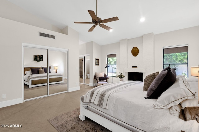 9821 E Windrose Dr, Scottsdale, AZ 85260 - bedroom featuring vaulted ceiling, carpet, multiple windows, a fireplace, and a ceiling fan