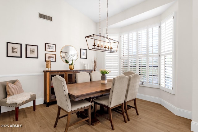 9821 E Windrose Dr, Scottsdale, AZ 85260 - dining space with light wood-style flooring and a chandelier