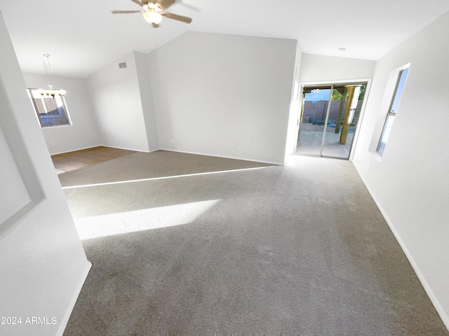 unfurnished room featuring ceiling fan with notable chandelier and vaulted ceiling