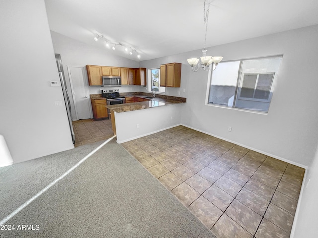 kitchen featuring stainless steel appliances, a notable chandelier, kitchen peninsula, lofted ceiling, and decorative light fixtures