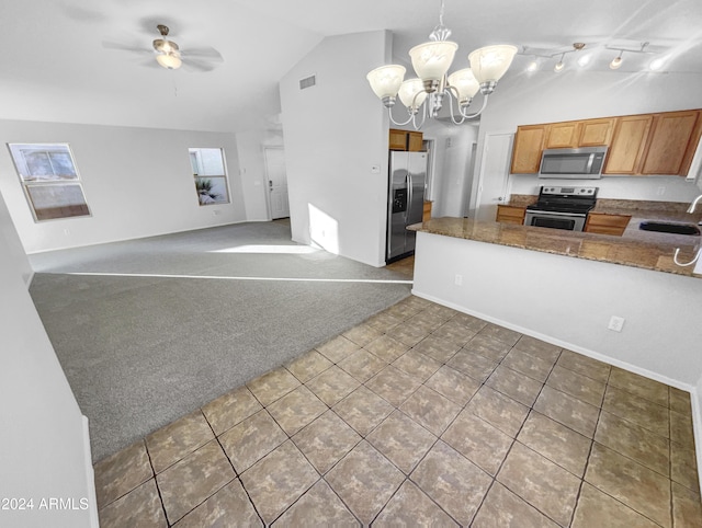 kitchen featuring ceiling fan with notable chandelier, stainless steel appliances, vaulted ceiling, sink, and pendant lighting