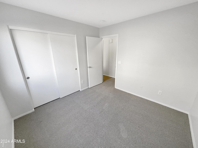 unfurnished bedroom with carpet floors and a closet