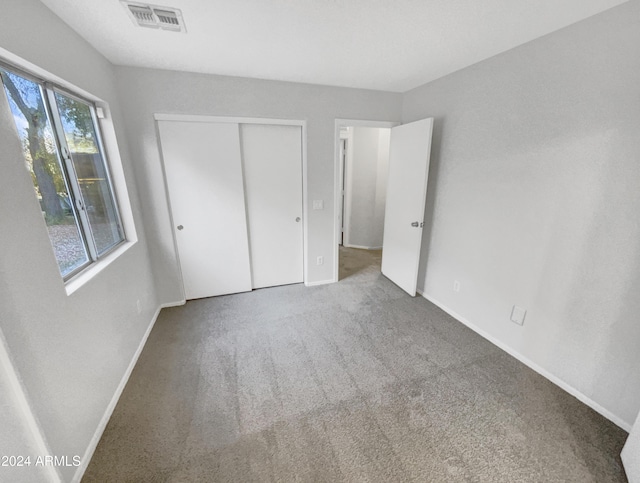 unfurnished bedroom with carpet floors and a closet