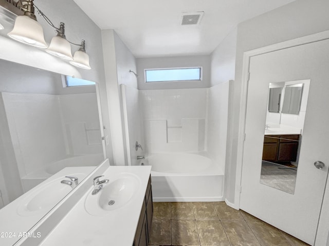 bathroom featuring washtub / shower combination, vanity, plenty of natural light, and tile patterned flooring