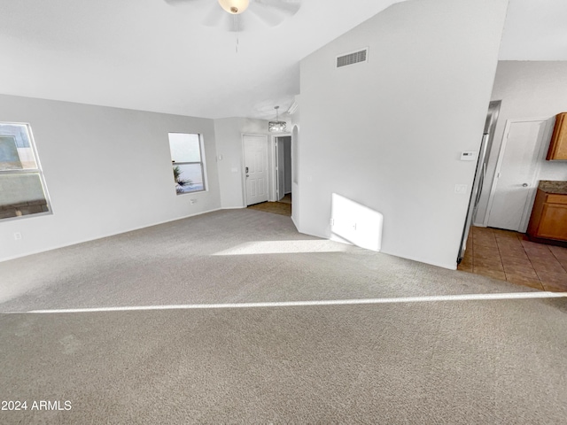 unfurnished room featuring ceiling fan, plenty of natural light, light carpet, and vaulted ceiling