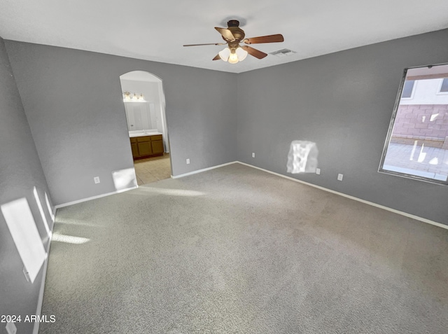 carpeted spare room featuring ceiling fan