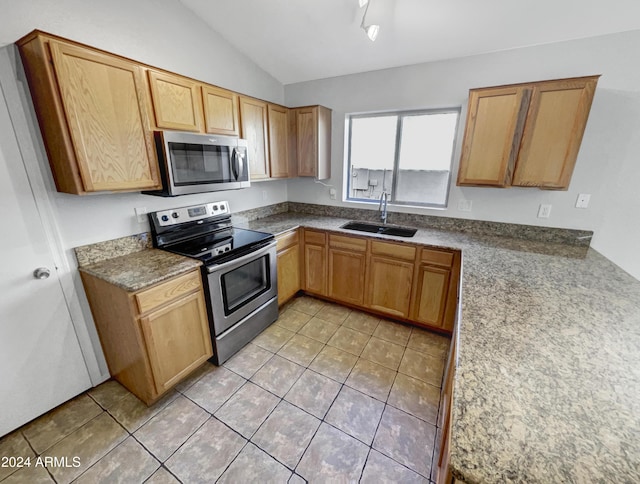 kitchen with light tile patterned floors, stainless steel appliances, lofted ceiling, and sink