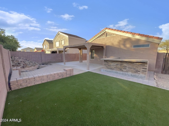 back of property featuring a yard and a patio