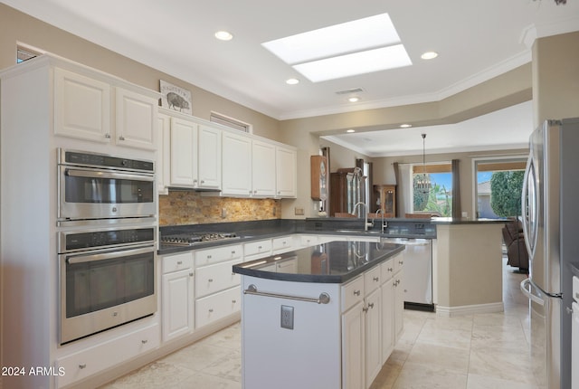 kitchen featuring light tile patterned flooring, appliances with stainless steel finishes, kitchen peninsula, and a kitchen island