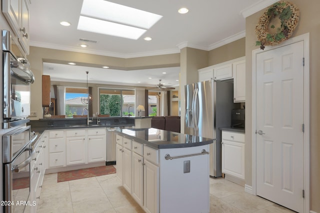 kitchen featuring light tile patterned floors, kitchen peninsula, a skylight, and a kitchen island