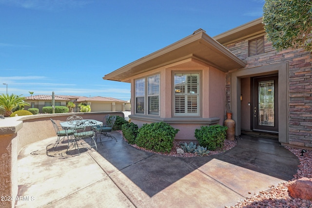 view of exterior entry featuring a patio area