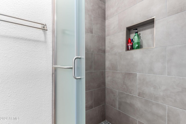 bathroom featuring a shower with door