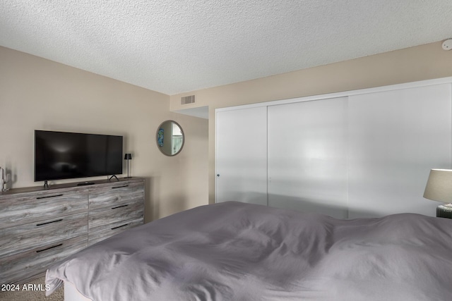 bedroom with a closet and a textured ceiling