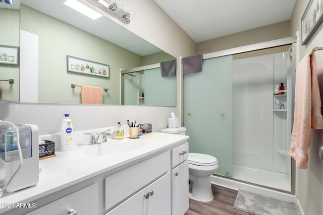 bathroom with vanity, hardwood / wood-style floors, an enclosed shower, and toilet