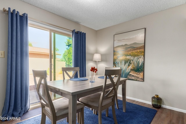 dining area with hardwood / wood-style flooring and a textured ceiling