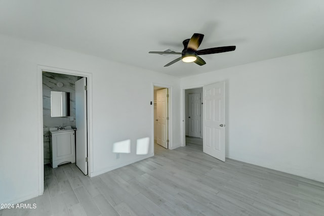 unfurnished bedroom featuring ceiling fan, light wood-type flooring, sink, and connected bathroom