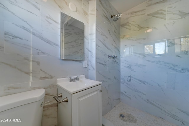 bathroom with vanity, toilet, and tiled shower