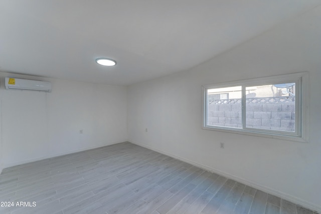 spare room with a wall mounted air conditioner and light wood-type flooring