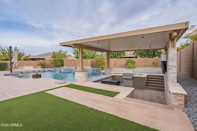 view of patio / terrace with pool water feature, a fenced in pool, exterior kitchen, and grilling area