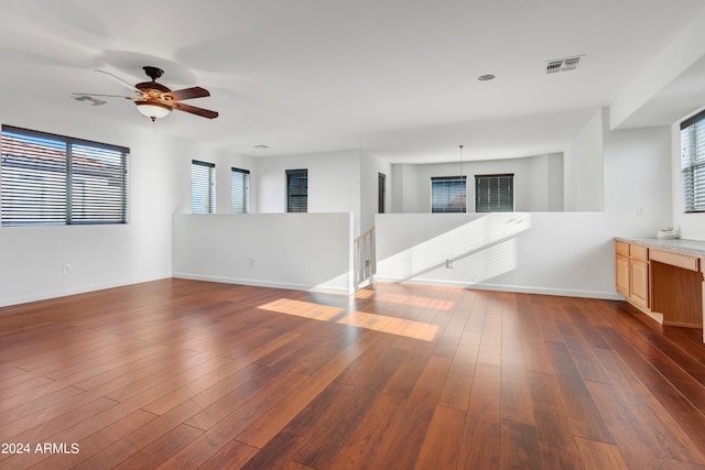 spare room with ceiling fan, dark hardwood / wood-style floors, and a healthy amount of sunlight