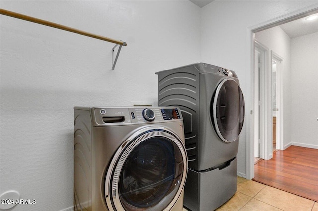 washroom featuring washing machine and dryer and light tile patterned floors