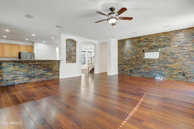 unfurnished living room featuring dark hardwood / wood-style floors and ceiling fan